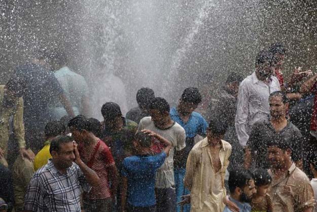 people cool off from the heat as they are sprayed with water jetting out from a leaking water pipeline in karachi pakistan june 25 2015 photo reuters